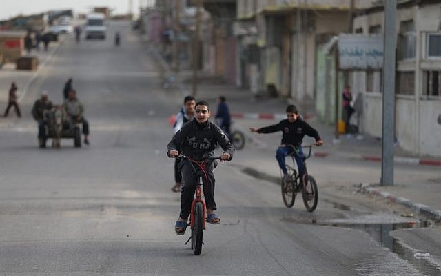 Des garçons palestiniens font du vélo dans la ville de Gaza le 8 mars 2018 (Crédit : AFP / MOHAMMED ABED)