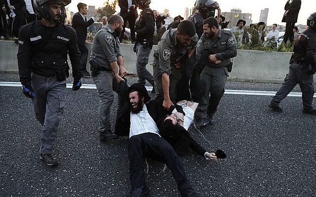La police évacue des manifestants ultra-orthodoxes qui bloquent une route lors d'une manifestation contre l'enrôlement de l'armée dans la ville de Bnei Brak, près de Tel-Aviv, le 12 mars 2018 (Crédit : AFP PHOTO / Ahmad GHARABLI) La police évacue des manifestants ultra-orthodoxes qui bloquent une route lors d'une manifestation contre l'enrôlement de l'armée dans la ville de Bnei Brak, près de Tel-Aviv, le 12 mars 2018 (Crédit : AFP PHOTO / Ahmad GHARABLI)