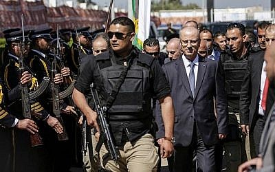 Le Premier ministre palestinien Rami Hamdallah, deuxième à droite, escorté de ses gardes du corps, est accueilli par les forces de police du Hamas, à gauche, à son arrivée à Gaza le 13 mars 2018. (AFP Photo/Mahmud Hams) Le Premier ministre palestinien Rami Hamdallah, deuxième à droite, escorté de ses gardes du corps, est accueilli par les forces de police du Hamas, à gauche, à son arrivée à Gaza le 13 mars 2018. (AFP Photo/Mahmud Hams)