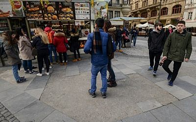 Des touristes sur le trottoir de la zone pédestre de la place Wenceslas à Prague, une rue formée d'anciennes tombes d'un cimetière juif abandonné, le 15 mars 2018 (Crédit :/ AFP PHOTO / Michal CIZEK)