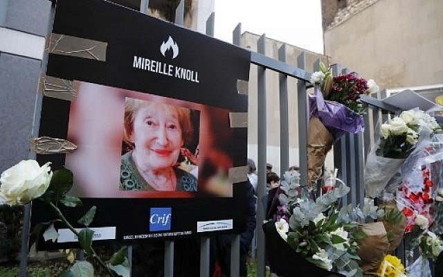 Une photo de Mireille Knoll et des fleurs sont placées sur la clôture entourant son immeuble à Paris, le 28 mars 2018 (Crédit : François Guillot / AFP) Une photo de Mireille Knoll et des fleurs sont placées sur la clôture entourant son immeuble à Paris, le 28 mars 2018 (Crédit : François Guillot / AFP)