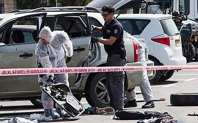 Les forces de sécurité israéliennes sur les lieux de l'attentat à la voiture piégée près de la gare dans la ville d'Akko, au nord du pays, le 4 mars 2018. (Meir Vaknin / Flash90)