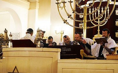 Le rabbin Michael Azoulay, deuxième à partir de la droite, lisant la Torah avec des fidèles à la synagogue de Neuilly-sur-Seine, le 11 décembre 2017. (Crédit : Cnaan Liphshiz / JTA)