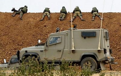 Des soldats israéliens sur la barrière terrestre le long de la frontière avec Gaza, à proximité du kibboutz israélien de  Nahal Oz, dans le sud du pays, le 30 mars 2018 (Crédit : Jack Guez/AFP)