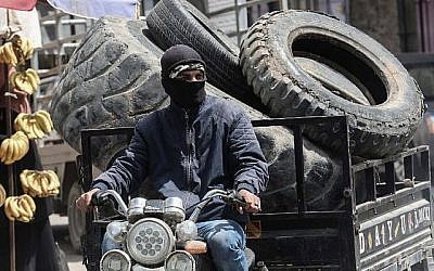 Un jeune Palestinien ramasse des pneus qui seront brûlés lors de manifestations le long de la frontière de Gaza à Khan Younès, dans le sud de la bande de Gaza, le 4 avril 2018. (Saïd Khatib/AFP)