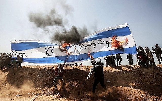 Des manifestants palestiniens brûlent un drapeau israélien lors d'affrontements avec les forces de sécurité israéliennes à la frontière entre Gaza et Israël, à l'est de Khan Younès, dans le sud de la bande de Gaza, le 6 avril 2018. (AFP PHOTO / DIT KHATIB) Des manifestants palestiniens brûlent un drapeau israélien lors d'affrontements avec les forces de sécurité israéliennes à la frontière entre Gaza et Israël, à l'est de Khan Younès, dans le sud de la bande de Gaza, le 6 avril 2018. (AFP PHOTO / DIT KHATIB)