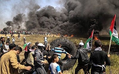 Des manifestants palestiniens brûlent des pneus lors d'affrontements avec les forces de sécurité israéliennes à la frontière entre Gaza et Israël, à l'est de la ville de Gaza, le 6 avril 2018. (AFP PHOTO / MAHMUD HAMS)