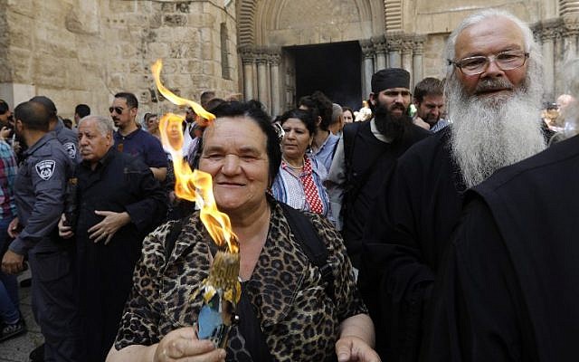 Les fidèles chrétiens orthodoxes tiennent des bougies allumées au "feu sacré" lors d'un rassemblement à l'église du Saint-Sépulcre de la Vieille Ville de Jérusalem lors de la Pâque orthodoxe, le 7 avril 2018
(Crédit : AFP PHOTO / GALI TIBBON) Les fidèles chrétiens orthodoxes tiennent des bougies allumées au "feu sacré" lors d'un rassemblement à l'église du Saint-Sépulcre de la Vieille Ville de Jérusalem lors de la Pâque orthodoxe, le 7 avril 2018
(Crédit : AFP PHOTO / GALI TIBBON)