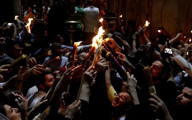 Les fidèles chrétiens orthodoxes tiennent des bougies allumées au "feu sacré" lors d'un rassemblement à l'église du Saint-Sépulcre de la Vieille Ville de Jérusalem lors de la Pâque orthodoxe, le 7 avril 2018
(Crédit : AFP PHOTO / GALI TIBBON) Les fidèles chrétiens orthodoxes tiennent des bougies allumées au "feu sacré" lors d'un rassemblement à l'église du Saint-Sépulcre de la Vieille Ville de Jérusalem lors de la Pâque orthodoxe, le 7 avril 2018
(Crédit : AFP PHOTO / GALI TIBBON)