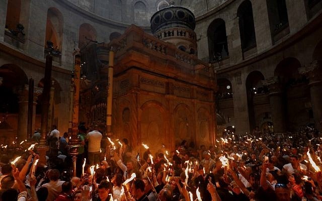 Les fidèles chrétiens orthodoxes tiennent des bougies allumées au "feu sacré" lors d'un rassemblement à l'église du Saint-Sépulcre de la Vieille Ville de Jérusalem lors de la Pâque orthodoxe, le 7 avril 2018
(Crédit : AFP PHOTO / GALI TIBBON) Les fidèles chrétiens orthodoxes tiennent des bougies allumées au "feu sacré" lors d'un rassemblement à l'église du Saint-Sépulcre de la Vieille Ville de Jérusalem lors de la Pâque orthodoxe, le 7 avril 2018
(Crédit : AFP PHOTO / GALI TIBBON)