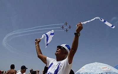 Les Israéliens regardent un spectacle aérien pendant les festivités du 70ème Jour de l'Indépendance, le 19 avril 2018 dans la ville côtière méditerranéenne de Tel Aviv (Crédit : AFP PHOTO / Ahmad GHARABLI)