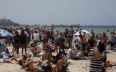 Des Israéliens et des touristes regardent un spectacle aérien pendant les festivités du 70ème Jour de l'Indépendance, le 19 avril 2018 dans la ville côtière méditerranéenne de Tel Aviv (Crédit : AFP PHOTO / AHMAD GHARABLI)