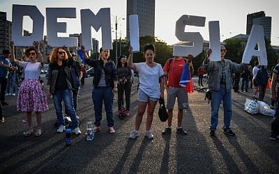 Des militants brandissent les lettres du mot "Démission" en roumain, devant les quartiers généraux du gouvernement, à Bucarest, le 27 avril 2018, pour réclamer la démission du Premier ministre Viorica Dancila à cause de la polémique sur le transfert de l'ambassade de Roumanie à Jérusalem. (Crédit : AFP/ Daniel MIHAILESCU)