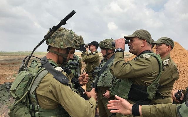 Le chef du Commandement du sud de l'armée israélienne, le général de division  Eyal Zamir,  regarde à travers une paire de lunette pour mieux voir la situation dans la bande de Gaza alors que le chef des opérations de l'armée, le général de division Nitzan Alon, se tient derrière durant une manifestation massive le long de la frontière, le 30 mars 2018 (Crédit : Armée israélienne)