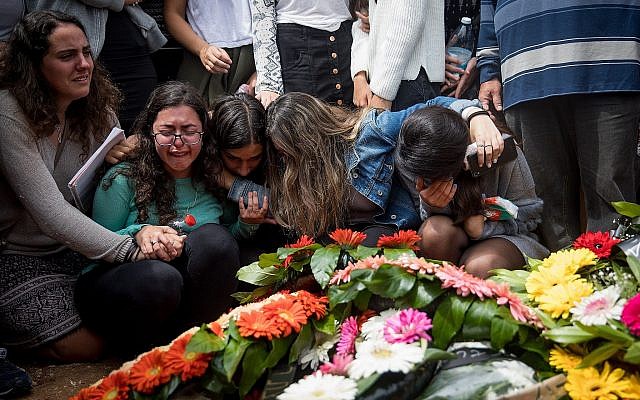 Les amis et la familles près de la tombe d'Ella Or au cours de ses funérailles à Mishor Adumim après sa mort, aux côtés de neuf autres adolescents, causée par une crue soudaine. Photo prise le 27 avril 2018 (Crédit : Yonatan Sindel/Flash90) Les amis et la familles près de la tombe d'Ella Or au cours de ses funérailles à Mishor Adumim après sa mort, aux côtés de neuf autres adolescents, causée par une crue soudaine. Photo prise le 27 avril 2018 (Crédit : Yonatan Sindel/Flash90)