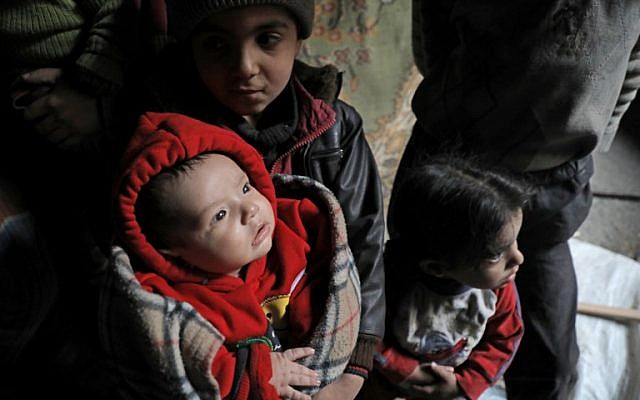 Des enfants syriens dans un sous-sol servant d'abri contre les frappes aériennes, le 25 mars 2018 à Douma, dans la Ghouta orientale, à la périphérie de Damas (PHOTO AFP / HAMZA AL-AJWEH)