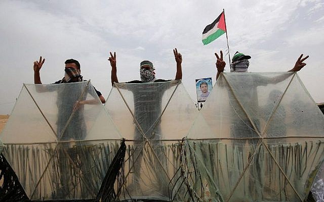 Des émeutiers palestiniens derrière des cerf-volants qu'ils s'apprêtent à faire voler au dessus de la frontière avec Israël, à Khan Younès, le 4 mai 2018 (Crédit : AFP/Said Khatib) Des émeutiers palestiniens derrière des cerf-volants qu'ils s'apprêtent à faire voler au dessus de la frontière avec Israël, à Khan Younès, le 4 mai 2018 (Crédit : AFP/Said Khatib)