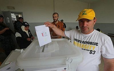 Un partisan libanais du groupe terroriste du  Hezbollah jette son bulletin lors des premières élections législatives depuis 9 ans dans un bureau de vote de la ville majoritairement chiite de Baalbeck,dans l'est de la vallée de Bekaa, à proximité de la frontière avec la Syrie, le 6 mai 2018 (Crédit : AFP PHOTO / Haitham MOUSSAWI)