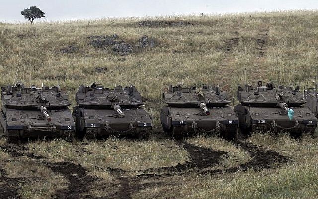 Des chars israéliens Merkava Mark IV prennent position près de la frontière syrienne dans le plateau du Golan le 9 mai 2018. (Crédit : AFP PHOTO / JALAA MAREY)