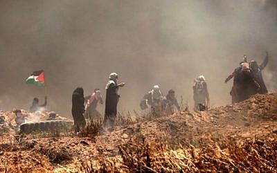 Des manifestants palestiniens lors d'affrontements avec les forces israéliennes près de la frontière entre Gaza et Israël, à l'est de Gaza City, le 14 mai 2018 (Crédit : AFP PHOTO / MAHMUD HAMS)
