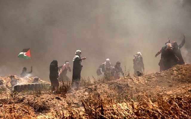 Des manifestants palestiniens lors d'affrontements avec les forces israéliennes près de la frontière entre Gaza et Israël, à l'est de Gaza City, le 14 mai 2018 (Crédit : AFP PHOTO / MAHMUD HAMS) Des manifestants palestiniens lors d'affrontements avec les forces israéliennes près de la frontière entre Gaza et Israël, à l'est de Gaza City, le 14 mai 2018 (Crédit : AFP PHOTO / MAHMUD HAMS)