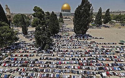 Les fidèles musulmans prient à proximité du Dôme du rocher et de la mosquée Al-Aqsa sur le mont du Temple de Jérusalem pendant les premières prières du vendredi du mois du Ramadan, le 18 mai 2018 (Crédit : AFP Photo/Ahmad Gharabli)
