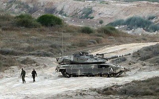 Des soldats israéliens marchent près d'un char de l'armée patrouillant le long de la frontière entre Israël et la bande de Gaza le 29 mai 2018. (AFP PHOTO / Jack GUEZ) Des soldats israéliens marchent près d'un char de l'armée patrouillant le long de la frontière entre Israël et la bande de Gaza le 29 mai 2018. (AFP PHOTO / Jack GUEZ)