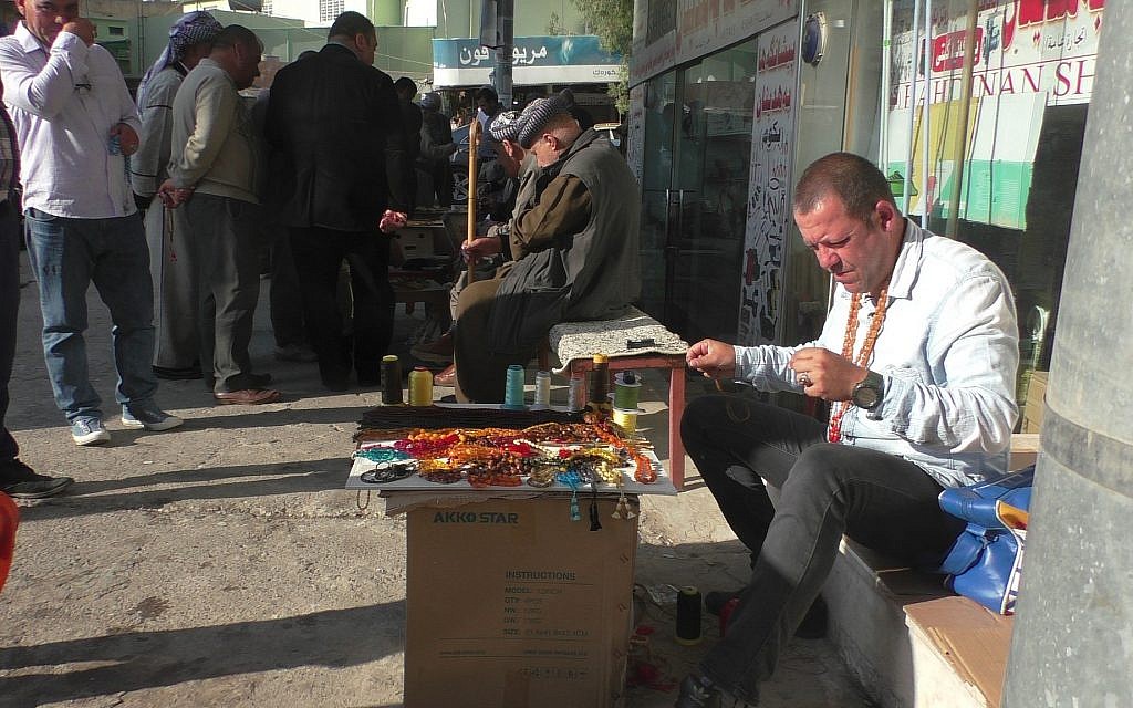Un homme vend des colliers de prière dans la rue à Dohuk, au Kurdistan irakien, le jour des élections, le 12 mai 2018 (Ziv Genesove / Times of Israël)