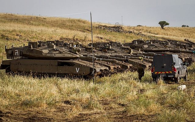 Soldats israéliens observés à côté de chars près de la frontière israélo-syrienne sur le plateau du Golan le 10 mai 2018. (Basel Awidat/Flash90) Soldats israéliens observés à côté de chars près de la frontière israélo-syrienne sur le plateau du Golan le 10 mai 2018. (Basel Awidat/Flash90)