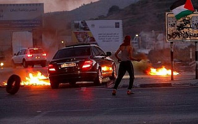 Des manifestants palestiniens affrontent les forces de sécurité israéliennes lors d'affrontements survenus aux abords du check-point de Hawara, au sud de la ville de Naplouse, en Cisjordanie, le 14 mai 2018 (Crédit : Nasser Ishtayeh/Flash90)