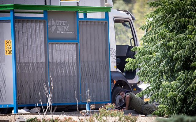 Un soldat israélien sur le côté de la rue pendant une sirène d'alarme avertissant d'une arrivée de roquette en provenance de Gaza, dans le sud d'Israël, le 29 mai 2018. (Crédit : Yonatan Sindel/Flash90)