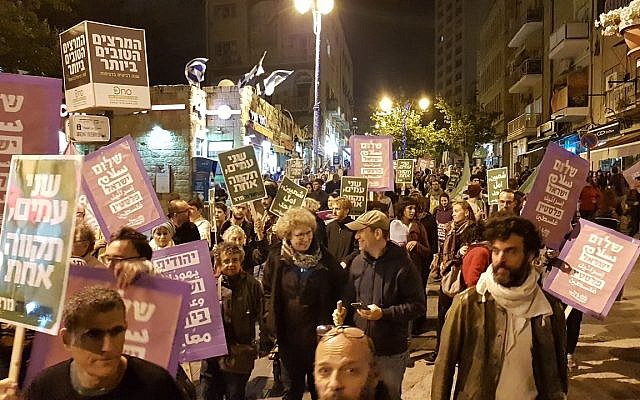 Des manifestants dénoncent le transfert de l'ambassade américaine à Jérusalem durant un défilé dans le centre de Jérusalem le 12 mai 2018 (Autorisation : Standing Together)