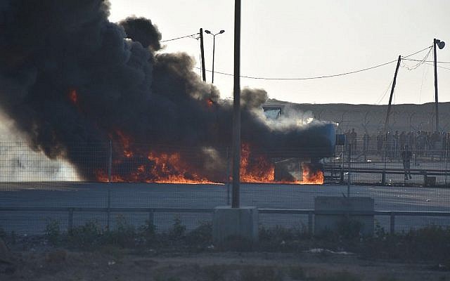 Les émeutiers palestiniens mettent le feu au carrefour de Kerem Shalom dans la bande de Gaza, le 14 mai 2018 (Crédit : Armée israélienne) Les émeutiers palestiniens mettent le feu au carrefour de Kerem Shalom dans la bande de Gaza, le 14 mai 2018 (Crédit : Armée israélienne)
