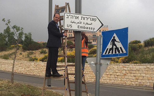 Le maire de Jérusalem Nir Barkat accroche le premier panneau signalant l'ambassade américaine à Jérusalem, le 7 mai 2018 (Crédit : Municipalité de Jérusalem)