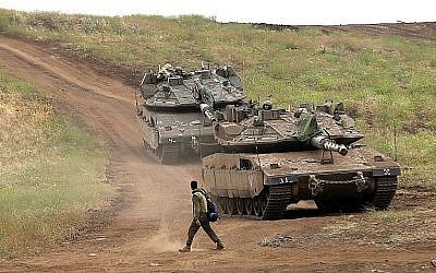 Un soldat israélien près d'un tank Merkava Mark IV sur le plateau du Golan durant un 
 mai exercice militaire, sur le plateau du Golan  (Crédit : AFP PHOTO / JALAA MAREY)
