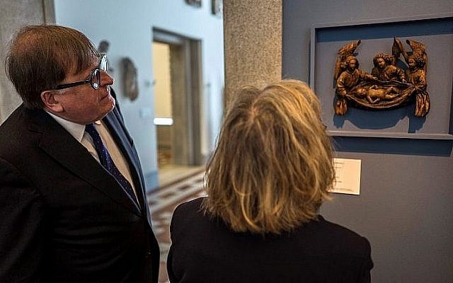 Un des héritiers d'anciens propriétaires, un couple juif qui a fui le régime nazi, Felix de Marez Oyens (G) et son épouse Théodora de Marez Oyens se tiennent devant une sculpture religieuse en bois du 15e siècle lors de sa restitution, le 25 juin 2018 , à Berlin. (Crédit : AFP / Bernd von Jutrczenka)