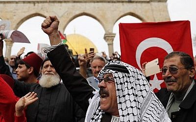 Des fidèles musulmans brandissent des drapeaux palestiniens et turcs après la prière du vendredi à la mosquée Al-Aqsa située sur le Mont du Temple dans la Vieille Ville de Jérusalem,  le 22 décembre 2017. (AFP Photo/Ahmad Gharabli)