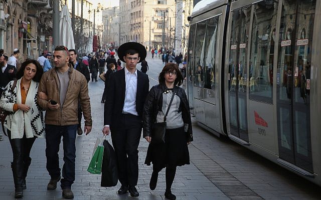 Un jeune couple laïque israélien marche à côté d'un couple ultra-orthodoxe alors que le tramway passe rue Jaffa dans le centre de Jérusalem le 22 janvier 2014. (Hadas Parush/Flash 90) Un jeune couple laïque israélien marche à côté d'un couple ultra-orthodoxe alors que le tramway passe rue Jaffa dans le centre de Jérusalem le 22 janvier 2014. (Hadas Parush/Flash 90)