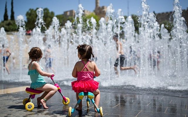 Des enfants jouent dans une fontaine, près de la Tour de David, dans la Vieille Ville de Jérusalem, le 17 avril 2016. (Crédit : Corinna Kern/Flash90)