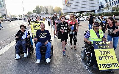 Des personnes handicapées, des invalides et des activistes bloquent une route alors qu'ils prennent part à une manifestation pour réclamer de meilleurs soins de santé et de meilleures allocations à Tel Aviv le 31 mai 2018. (Photo : Tomer Neuberg/Flash90)