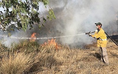 Un pompier éteint un incendie à la frontière israélienne avec Gaza, le 11 juin 2018. (Sam Sokol)