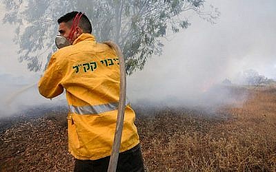 Un pompier du KKL-JNF tente d'éteindre un incendie dans le sud d'Israël, près de la frontière de Gaza, causé par des cerfs-volants incendiaires envoyés depuis la bande de Gaza. (Yehuda Peretz/KKL-JNF/Autorisation)
