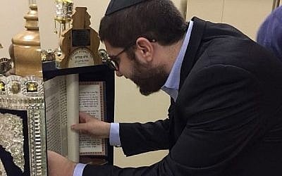 Le rabbin Mendy Aboutboul de la synagogue Edmond J. Safra Ipanema à Rio de Janeiro inspecte le rouleau de haftarah trouvé par la police dans un bidonville local, le 28 mai 2018. (Avec l'aimable autorisation de Edmond J. Safra Ipanema synagogue via JTA)