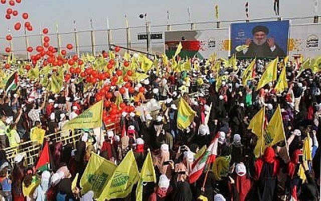 La foule brandit les drapeaux de l'organisation terroriste libanaise Hezbollah (jaune) et les drapeaux nationaux libanais lors de la Journée de Jérusalem dans le village de Maroun al-Ras, près de la frontière israélo-libanaise, le 8 juin 2018. (Crédit : AFP Photo/Mahmoud Zayyat)