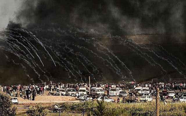 Les militaires israéliens lancent du gaz lacrymogène vers les manifestants à l'est de Gaza City le long de la frontière entre la bande de Gaza et Israël, le 29 juin 2018, durant des affrontements avec les Palestiniens (Crédit : AFP PHOTO / MAHMUD HAMS) Les militaires israéliens lancent du gaz lacrymogène vers les manifestants à l'est de Gaza City le long de la frontière entre la bande de Gaza et Israël, le 29 juin 2018, durant des affrontements avec les Palestiniens (Crédit : AFP PHOTO / MAHMUD HAMS)