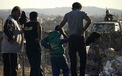 Un militaire de l'armée jordanienne sur une jeep derrière les fils barbelés délimitant un camp de fortune qui accueille les Syriens déplacés de la province de Daraa qui ont fui les frappes des forces pro-gouvernementales,  de la ville de  Nasib, dans le sud de la Syrie, le 2 juillet 2018 (Crédit : AFP Photo/Mohamad Abazeed)