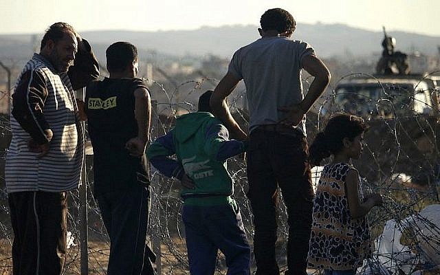 Un militaire de l'armée jordanienne sur une jeep derrière les fils barbelés délimitant un camp de fortune qui accueille les Syriens déplacés de la province de Daraa qui ont fui les frappes des forces pro-gouvernementales,  de la ville de  Nasib, dans le sud de la Syrie, le 2 juillet 2018 (Crédit : AFP Photo/Mohamad Abazeed)