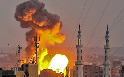 Une boule de feu explose dans Gaza City pendant une frappe israélienne (Crédit : AFP / BASHAR TALEB)