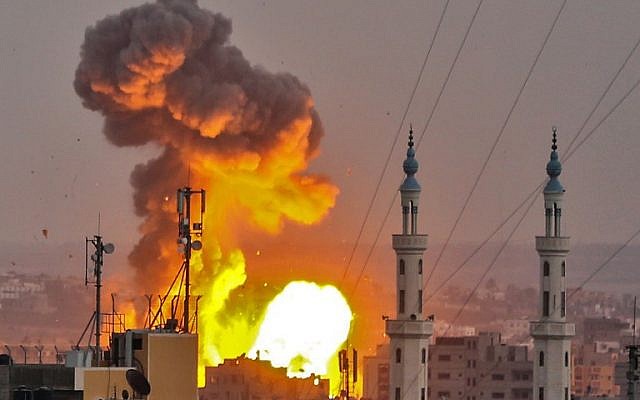 Une boule de feu explose dans Gaza City pendant une frappe israélienne (Crédit : AFP / BASHAR TALEB)