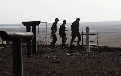 Des soldats israéliens sur la colline Tel Saki, sur le plateau du Golan annexé par Israël, de l'autre côté de la frontière de la province de Deraa en Syrie, le 24 juillet 2018 (Crédit :  / AFP PHOTO / JALAA MAREY)